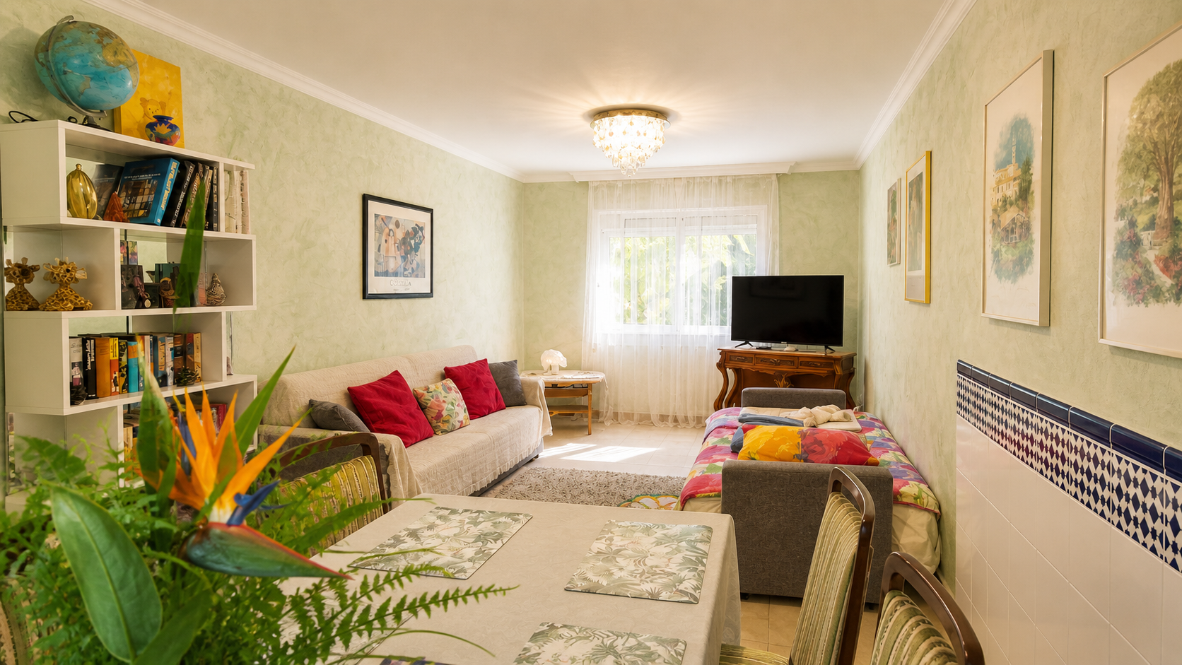 Bright living and dining area in the Family Apartment with sofa, additional bed and television